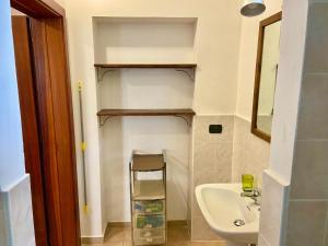 a bathroom with a sink and a toilet and a shelf at Casa di Marco in Galatina