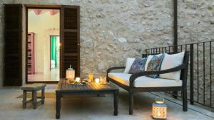 a porch with a chair and a table and candles at Casa Abeurador in Artá