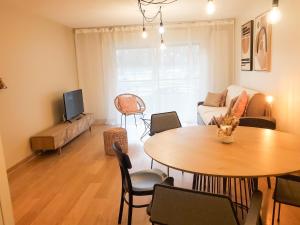 una sala de estar con una mesa y un sofá en Standing appartement avec vue sur la Mayenne, en Laval