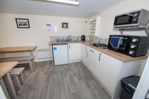 a small kitchen with a counter and a microwave at Seaways glamping, Copper Beech in Great Driffield