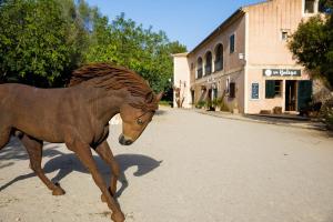 un caballo marrón caminando por una calle al lado de un edificio en Finca Agroturismo Son Menut, en Felanitx