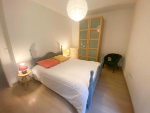 ein kleines Schlafzimmer mit einem Bett und einem Stuhl in der Unterkunft CityCosy Strasbourg - Neudorf Garden Bucarest in Straßburg