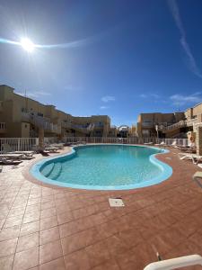 a large swimming pool in the middle of a resort at Caleta Sunset in Caleta De Fuste