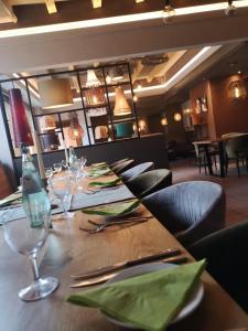 a table in a restaurant with a bottle and glasses at Hotel-Restaurant Laux in Merzig