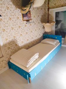 a blue bed in a room with a wall at Night in Upsidedown House in Petrovo