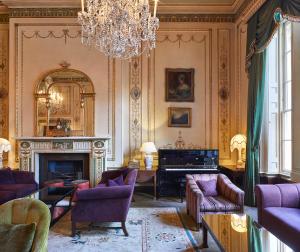 倫敦的住宿－Home House - Private Member's Club，客厅设有壁炉和吊灯。