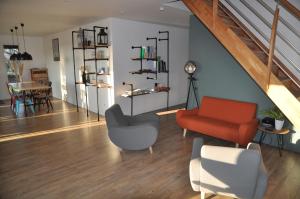 sala de estar con silla roja y mesa en L'Atelier, en Sainte-Marie-du-Lac-Nuisement 