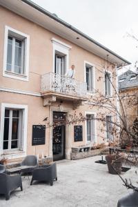 un homme debout sur le balcon d'un bâtiment dans l'établissement Hotel Spa Azteca Barcelonnette, à Barcelonnette