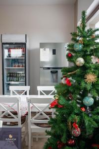 a green christmas tree in a room with a kitchen at AristoCat Hotels Rasnov in Râşnov