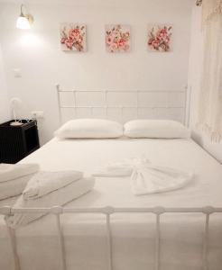 białe łóżko z białą pościelą i ręcznikami w obiekcie Studio by the sea w Kardamenie
