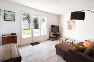 a living room with a couch and a table at La Cotinette in La Cotinière