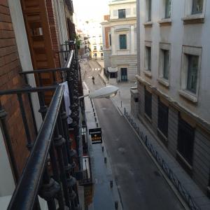 eine leere Stadtstraße mit Straßenbeleuchtung und Gebäuden in der Unterkunft Hostal Oporto in Madrid