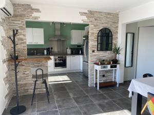 uma cozinha com armários brancos e uma parede de tijolos em Villa Ghjuvan - Sea, Mountain & Spa em Peri