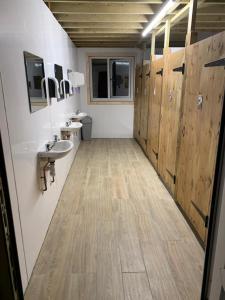 a bathroom with a sink and a toilet and wooden doors at Swaledale Shepherd's Hut in Newton Abbot