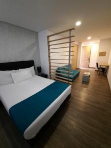 um quarto com uma cama grande e um quarto com uma secretária em Apartahotel Boutique Central em Bogotá