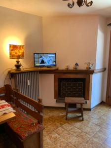 un salon avec une télévision et une cheminée dans l'établissement Appartamento panorama, à Folgarida
