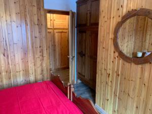 a bedroom with a red bed and a mirror at Appartamento panorama in Folgarida