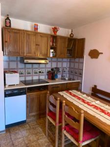 a kitchen with wooden cabinets and a wooden table at Appartamento panorama in Folgarida