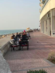 a group of people sitting at tables on the beach at BEAUTIFUL STUDIO APARTMENT IN AL MARJAN ISLAND in Ras al Khaimah