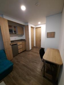 Habitación pequeña con mesa y cocina en Apartahotel Boutique Central, en Bogotá