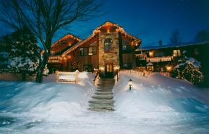 una casa cubierta de nieve con luces encendidas en The Snowed Inn en Killington