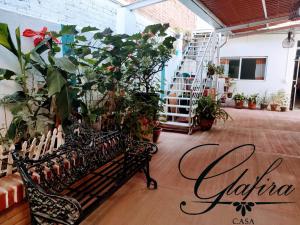 eine Bank in einem Raum voller Pflanzen in der Unterkunft Casa Glafira in Oaxaca de Juárez