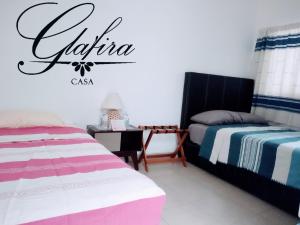 a bedroom with two beds and a sign on the wall at Casa Glafira in Oaxaca City