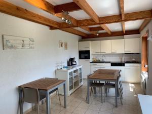 cocina con 2 mesas, mesa y sillas en Nieuwendamme 14, en Nieuwpoort