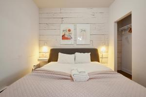 1 dormitorio con 1 cama blanca grande y 2 lámparas en NEW Spacious Industrial Loft in Le Plateau by Den Stays en Montreal