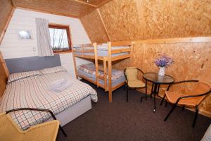 1 dormitorio con litera, mesa y sillas en Seaways glamping, Redwood, en Great Driffield