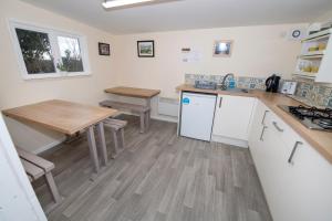 a kitchen with a wooden table and a table and a table and chairs at Seaways glamping, Redwood in Great Driffield