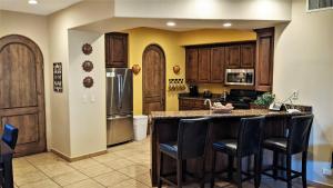 a kitchen with wooden cabinets and a island with bar stools at Bella Sirena 601-D in Puerto Peñasco