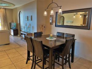 a dining room table with chairs and a mirror at Bella Sirena 601-D in Puerto Peñasco