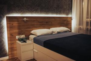 a bedroom with a bed with a wooden headboard at My Space apartment in Subotica