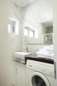 a white bathroom with a washing machine in it at Luka's Apartment Sarandë in Sarandë
