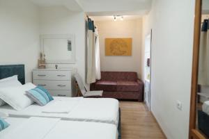 a small bedroom with two beds and a couch at Luka's Apartment Sarandë in Sarandë