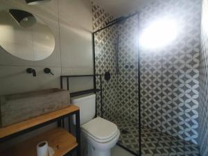 a bathroom with a toilet a sink and a shower at Trastienda Guest House in El Calafate