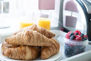 a plate of croissants and fruit on a table at Conwy View Cottage in Conwy