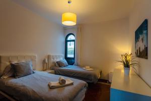 - une chambre avec 2 lits et une fenêtre dans l'établissement Pérola do Mar, à Foz do Arelho