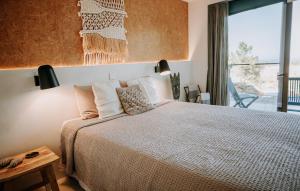 ein Schlafzimmer mit großem Bett und Fenster in der Unterkunft Eco-lodge Villa Epicurea in Sesimbra