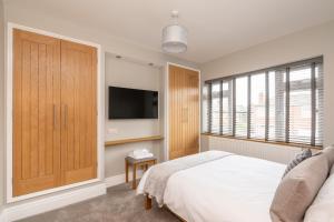 约克51 Main Avenue Luxurious Modern York House with Garden & Parking Pass the Keys的一间带床和平板电视的卧室