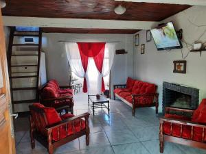 sala de estar con sillas rojas y chimenea en Serena, en Barra del Chuy