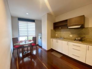 cocina con mesa y comedor en Apartasuites BellHouse Bogotá, en Bogotá