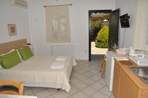 a bedroom with a bed and a kitchen with a sink at Handakas Studios in Andros