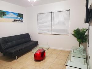 a living room with a black couch and a glass table at Singer Island Inn in West Palm Beach