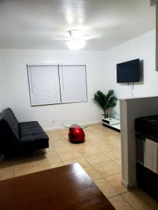 sala de estar con sofá negro y TV en Singer Island Inn, en West Palm Beach