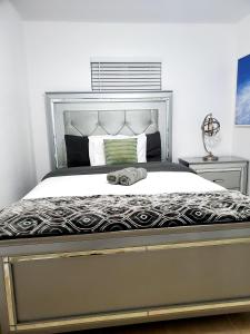 1 dormitorio con 1 cama grande con marco de plata en Singer Island Inn, en West Palm Beach