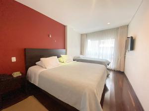 Säng eller sängar i ett rum på Apartasuites BellHouse Bogotá