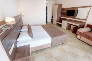 sypialnia z dużym łóżkiem i telewizorem w obiekcie Villa Edem w mieście Simejiz