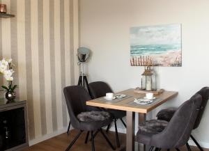 a dining room with a table and four chairs at Meerblick SL 75 in Norderney